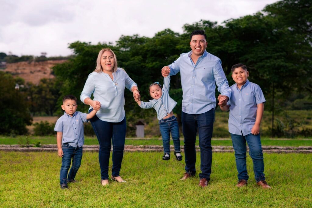 Family of five in matching outfits enjoying a sunny day outdoors.